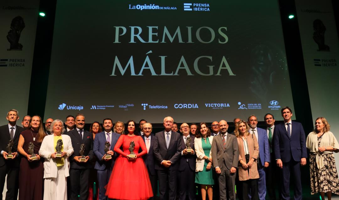 Premiados en el escenario del AC HOTEL BY MARRIOTT MÁLAGA PALACIO y escenario con presentadora.