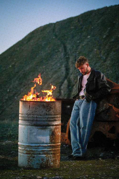 dani fernandez frene a un fuego en un tonel de lata