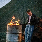 dani fernandez frene a un fuego en un tonel de lata